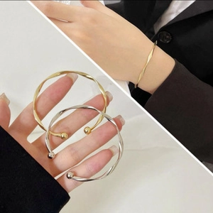 Detailed view of adjustable gold and silver wire bracelets with twisted ripple design