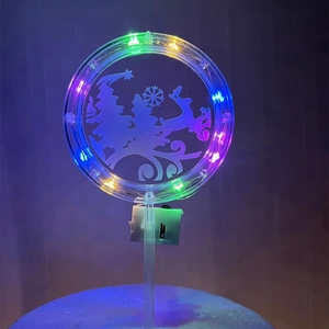 Close-up of LED Christmas cake topper with RGB lights and a clear acrylic surface