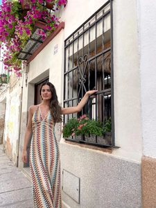 Vue détaillée d'une robe longue au crochet à rayures colorées avec décolleté licou