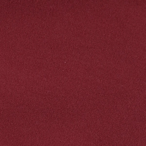 Close-up of high-quality burgundy lace fabric showing detailed knit texture of the dress