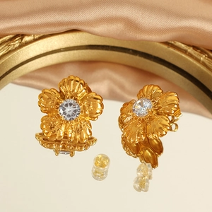 Vintage gold flower stud earrings with clear zircon center and champagne satin backdrop