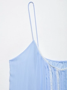 Detail of light blue camisole with delicate white lace trim and textured fabric weave