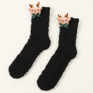 Detail von flauschigen schwarzen Korallenvlies-Socken mit rosa Rentier und grüner Schleife