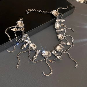 Close-up of sparkling silver necklace with large rectangular crystals and rhinestone tassels