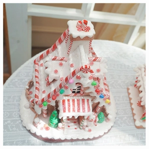 Detailed view of a lighted Christmas gingerbread house with candy textures and snowy details
