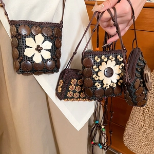 Detailed macro view of handmade coconut shell bags with floral resin accents and wooden beads