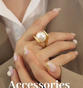 Detail of a large imitation pearl on a Y-shaped gold-plated titanium steel ring