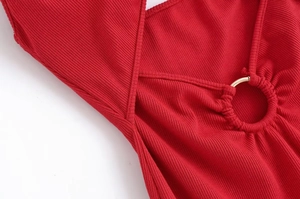 Dettaglio dell'abito midi in maglia rossa con texture a costine e cerchio metallico