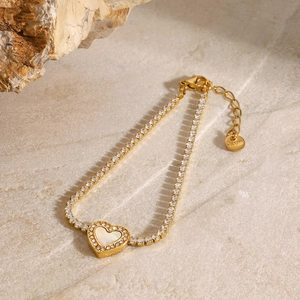 Dettaglio del bracciale in acciaio dorato con pavé di zirconi e ciondolo a cuore