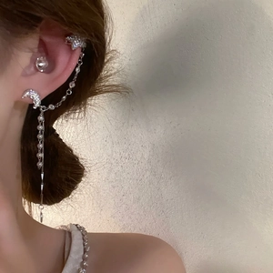 Close-up detail of moon earring and star ear cuff with sparkling crystal tassels