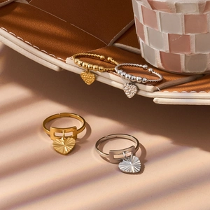 Detail of vintage heart rings in gold and silver finish with textured enamel pendants