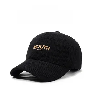 Close-up of black waffle texture baseball cap with detailed gold MOUTH embroidery