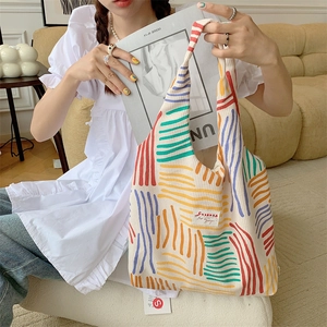Detail view of corduroy tote bag featuring colorful retro stripes and brand woven label