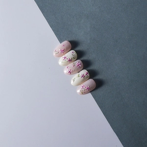 Détail de stickers fleurs 3D en relief sur ongles ovales avec élégants motifs floraux