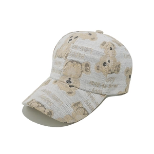 Detail shot of a cream baseball cap with cute cartoon bear prints and happy text embroidery