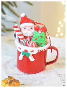 Festive red snowman mug ornament with miniature Christmas tree and candy canes in snow