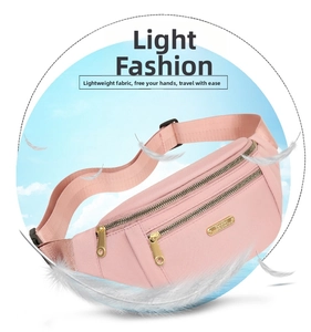 Detail of light pink fanny pack showing multiple gold zipper compartments and metal plate