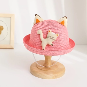 Detailed view of pink straw sun hat for children with 3D cat ears and cute kitten patch