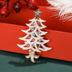 Detailed view of enamel Christmas tree brooch with colorful rhinestones on festive background