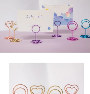 Close-up of heart-shaped metal memo clips in various electroplated colors on spiral bases