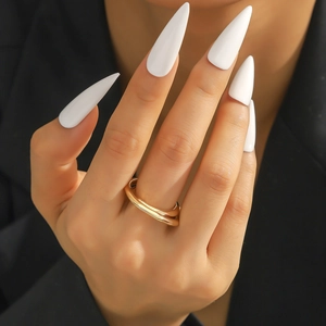 Minimalistischer goldener Zirkonring im doppelten Wellendesign am Finger des Models