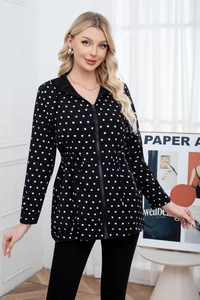 Detail of a black and white polka dot hooded jacket with an adjustable waist drawstring