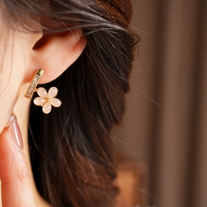 Detailed view of elegant pink flower earring with gold rectangular zircon bar on model