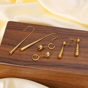 Polished 18k gold plated teardrop and bead earrings set on elegant silk and wood display