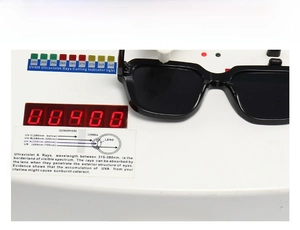 Testing black thick frame sunglasses for UV400 protection on a professional UV tester