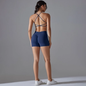 Detail view of seamless cross-back sports bra and scrunch butt gym shorts in navy blue