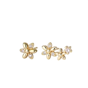 Elegant asymmetrical gold flower stud earrings with white zircons on white background