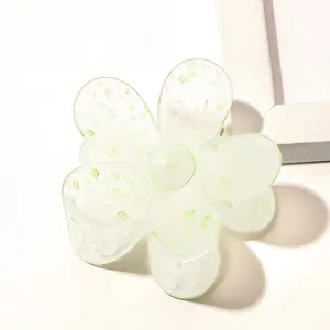 Detail of flower hair claw clip in translucent mint green matte finish with green speckles