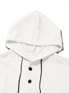 Close-up of white hoodie neckline with buttons and textured jacquard fabric detail