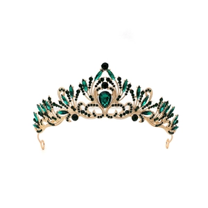 Detailed macro view of vintage baroque gold crown with emerald crystals and black rhinestones