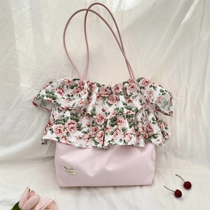 Dettaglio della borsa a spalla rosa con balze floreali e logo del marchio