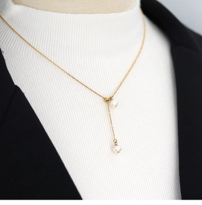 Detailed close-up of a gold Y-shaped necklace with natural freshwater pearls and tassel