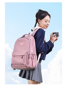 Side view of a pink nylon school backpack featuring multiple storage pockets