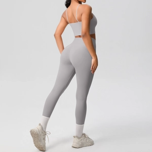 Detail of grey yoga set showing high-waisted leggings and thin strap sports bra on model