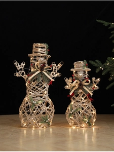 Close-up of lighted champagne snowman decor with warm LED lights and pine cone detail