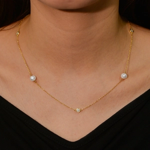 Elegant gold sterling silver necklace with freshwater pearls and sparkling zircon on model