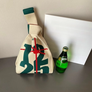 Gros plan sur le sac en tricot crème avec numéros verts et rubans de Noël rouges