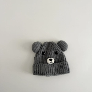 Détail du bonnet d'hiver gris en maille épaisse avec oreilles d'ours et yeux en boutons