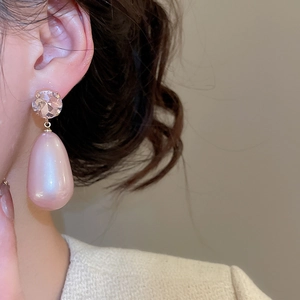 Macro detail of French vintage drop earrings with pink teardrop pearls and clear crystals