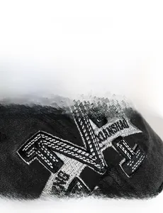 Close-up of high-density 3D letter M embroidery on vintage black cotton baseball cap