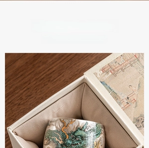 Close-up of premium ceramic tea cup with silver-plated dragon motif in an elegant gift box