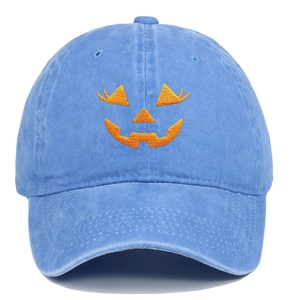 Detailed embroidery of a smiling pumpkin face on a blue washed denim baseball cap