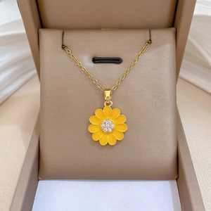 Detailed close-up of yellow sunflower pendant with crystal core on gold-tone chain