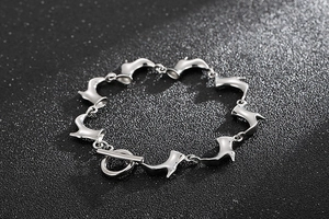 Détail du bracelet en acier titane argenté avec breloques bottes et fermoir à bascule
