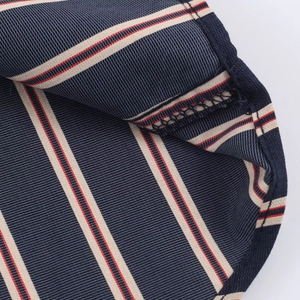 Macro detail of high-density navy blue striped fabric with precision overlock stitching