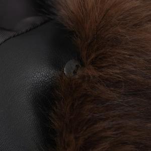 Detail of dark brown faux fur collar and black leather coat with a round button